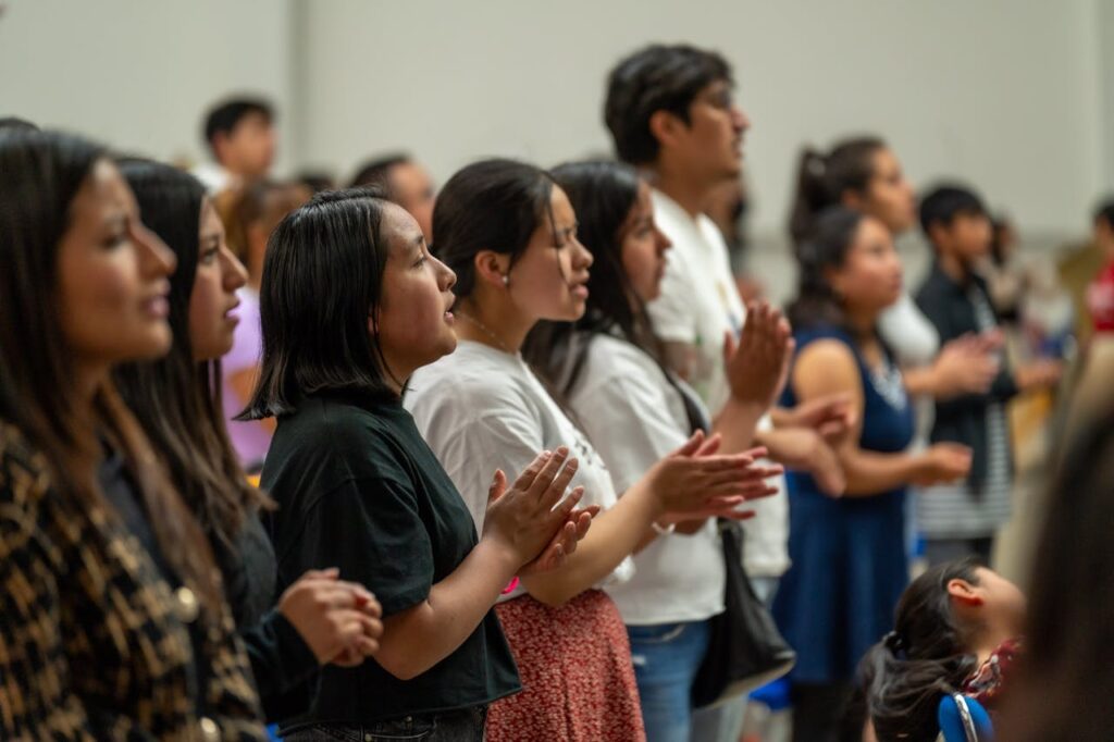 A group of people standing in a room clapping